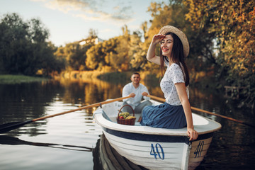 Fototapeta na wymiar Pretty lady poses in boat on quiet lake