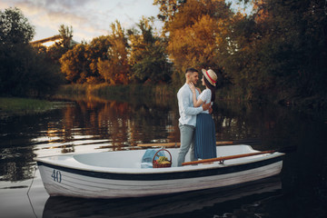 Fototapeta na wymiar Lovers hugs in a boat on quiet lake at summer day