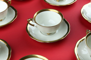 vintage ceramic cup and saucer with gilding on a red background