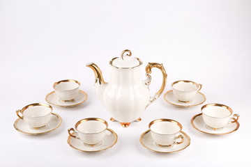antique porcelain cups with gilding on a white background. vintage tea set