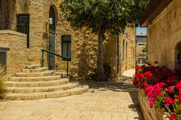 Naklejka premium old Europe medieval city street with red flower bed stone alley and living buildings colorful urban photography