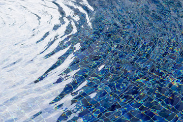 Fototapeta na wymiar Soft focus background, water in swimming pool with blue tile. Relax, spa concept.