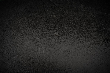 Texture of black granite wet stone with traces of grinding