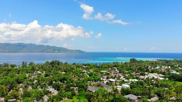 Tropical island with village and turquoise ocean, aerial view. Gili islands