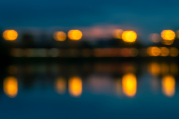 Blurred image for background. Night traffic and lanterns lights with reflection in water..
