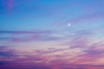 Red sunset sky with crescent moon..