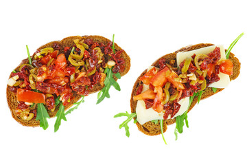 Pieces of rye bread with cheese, dried tomatoes, olives and vegetables isolated on white background