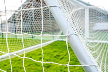 Shallow focus of a newly delivered football goal located in a village park. Detail of the white...