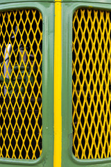Front, Motorhaube, Kühlergrill eines Oldtimertraktors in grün mit gelbem Mittelstreifen und gelbem Rautenförmigen Lufteinlassgitter und Blick auf den dahinterliegenden in Motor .