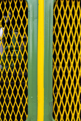 Front, Motorhaube, Kühlergrill eines Oldtimertraktors in grün mit gelbem Mittelstreifen und gelbem Rautenförmigen Lufteinlassgitter und Blick auf den dahinterliegenden in Motor .