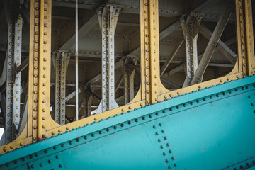 Steel beams on a railway bridge with steel plates and riveted connections. Landscape format.