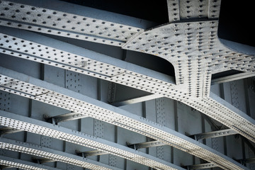 Steel beams on a railway bridge with steel plates and riveted connections. Landscape format.