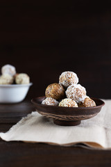 Energy protein balls on a dark wooden background. Healthy, nutritious and delicious snack. Vertical photo.