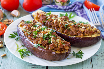 Healthy dinner. Snack. Stuffed with minced meat and vegetables eggplant on wooden table.