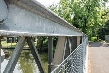 Close-up, structural view of a metal footbridge on the former East and West German border crossing. Showing detail of the mesh fencing and narrow roadway on the right.