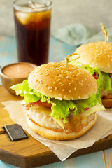 American snack Street food. Fast food. Homemade hamburger with bacon and cola drink on wooden rustic table.