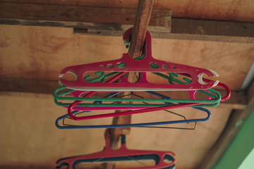 Many wooden hangers on a rod