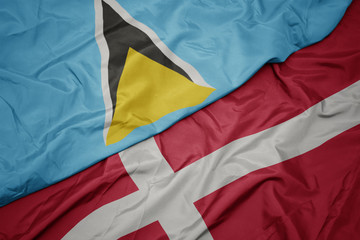 waving colorful flag of denmark and national flag of saint lucia.