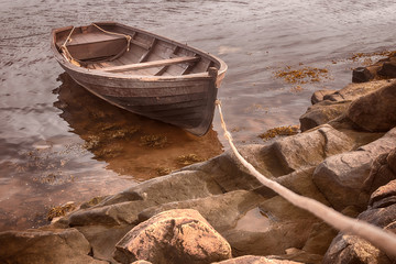 An old fishing boat is tethered near the shore of the White Sea. Selected focus. Toning.