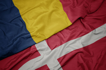 waving colorful flag of denmark and national flag of chad.