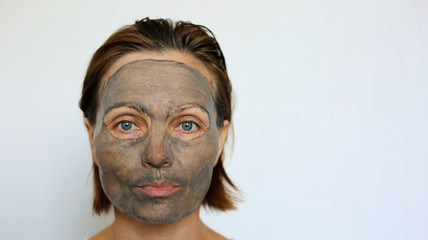 Beautiful Mature woman making face bubble charcoal mask. Surprised face. Face treatment and skincare. Popular Korean cosmetic product. Bubbling oxygen mask.