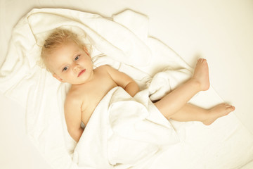 Top view of a baby on the bed wrapped in towel after having a bath