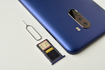 The hybrid tray with a SIM card and a memory card is removed from the smartphone with a sim ejector...