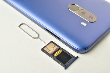 The hybrid tray with a SIM card and a memory card is removed from the smartphone with a sim ejector...