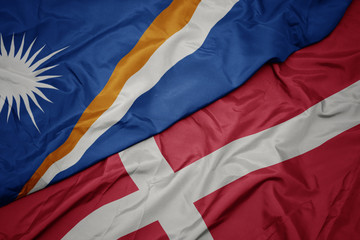 waving colorful flag of denmark and national flag of Marshall Islands .