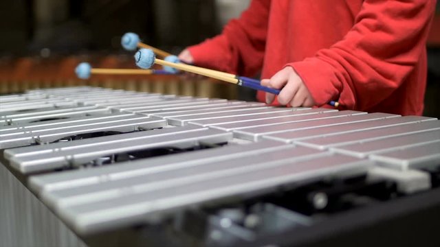 Man playing the vibraphone in red outfit