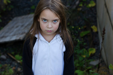 Little scared girl stands in the basement