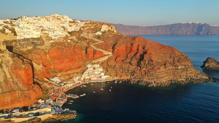 Aerial drone photo of world famous beautiful sunset at traditional and picturesque village of Oia with golden colours, Santorini island, Cyclades, Greece