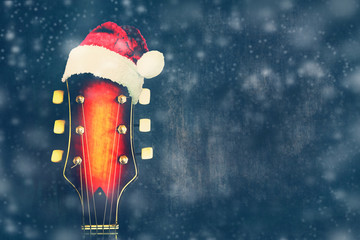 Vulture of electric guitar with Santa Claus Hat on a blue background. New Year's card for the...