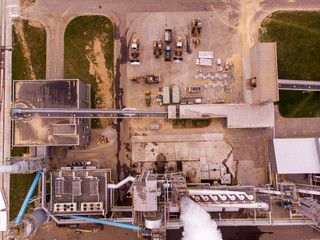 Wood processing plant pollutes the air with smoke coming from the pipe. Ecological problem of pollution of the environment of production by the plant of particle boards. Drone shooting from the air.