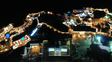 Aerial drone night shot of beautiful illuminated traditional and picturesque village of Oia built...