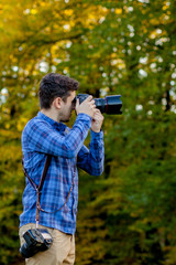 Fototapeta premium Professional photographer in action with two cameras on a shoulder straps