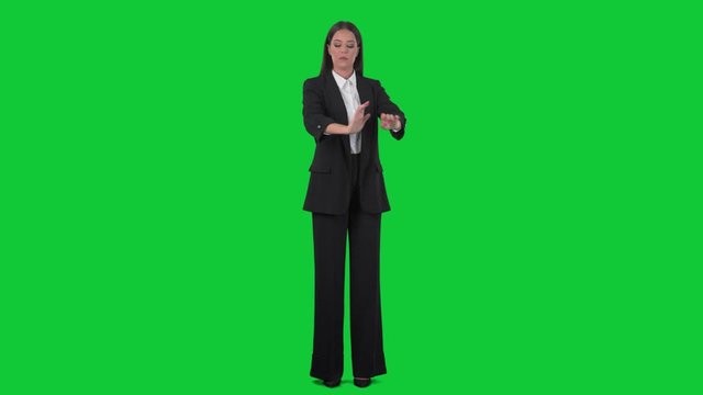 Elegant business woman in black suit preparing and getting ready for job. Full body isolated on green screen chroma key background