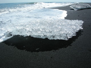 Ice on beach with black sand