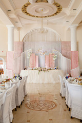 Festive table for the bride and groom decorated with cloth and flowers. Concept fresh floral