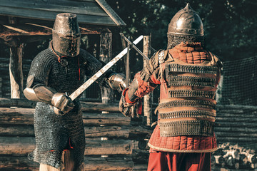 two knights in armor fight each other with swords until victory