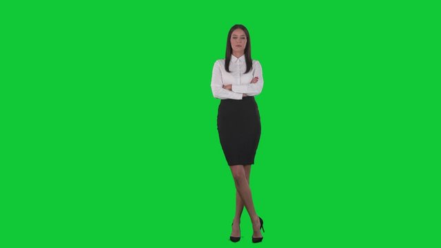 Serious strict business woman manager with crossed arms and authority. Full body isolated on green screen chroma key background
