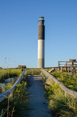 Obraz premium Oak Island North Carolina Lighthouse. View from the beach looking up at the top.