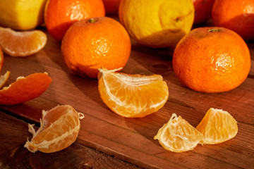 tangerines and lemons on dark table sunbathing