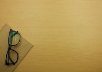 book and glasses on Wooden table