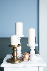 Naklejka premium Three Stylish white large candles on the table, and New Year's balls, photos in gentle pastel colors. Christmas mood