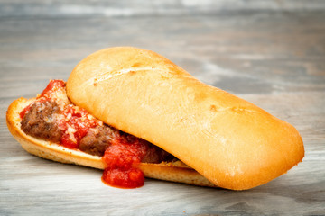 Lid of a submarine sandwich is install crooked with meatballs