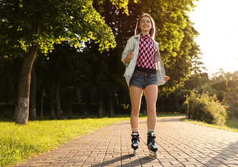 Beautiful young woman with roller skates having fun outdoors