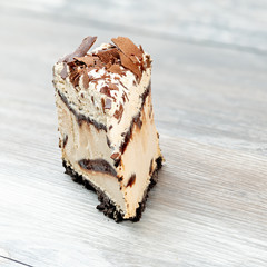 Triangular slice of sweet Ice Cream cake with chocolate shavings