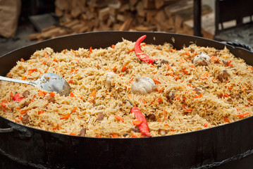 Large cauldron floating at the city fair. Red peppers, garlic, meat and incas in porridge.