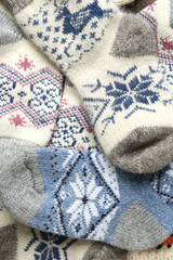 Different knitted woolen socks as background, closeup